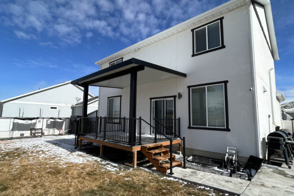 Sleek modern patio cover with black framing and open backyard layout