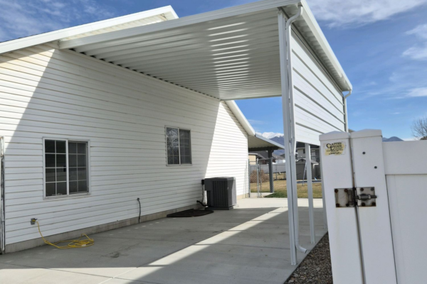 Narrow side yard covered with a metal patio awning attached to a home