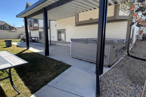 Covered walkway patio area along the side of a house with support posts and metal roofing